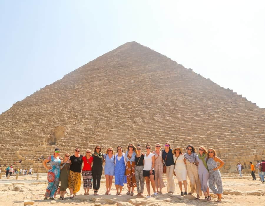 Travellers standing in front of the Giza pyramids in Egypt